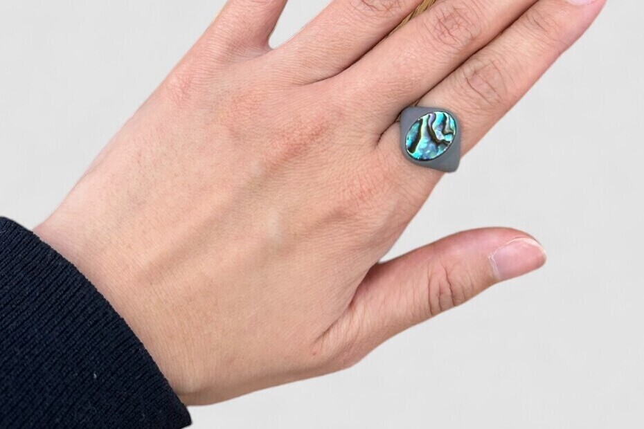 本制作前の樹脂サンプルリングを指にはめてサイズ感を確認している様子